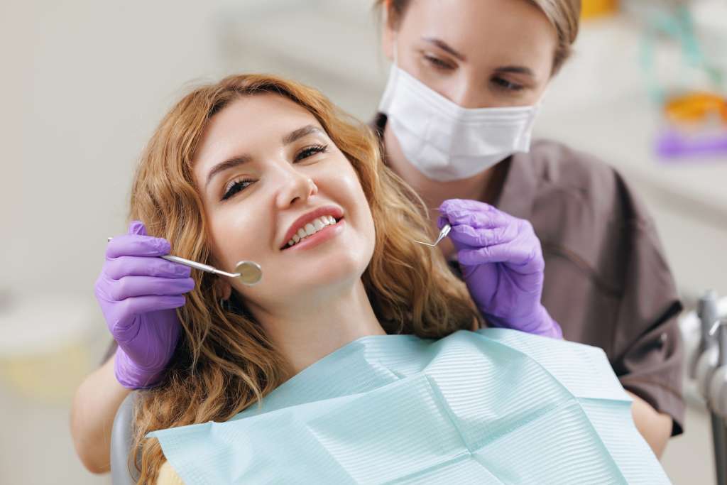 Dentist examining a patient's smile with a dental mirror